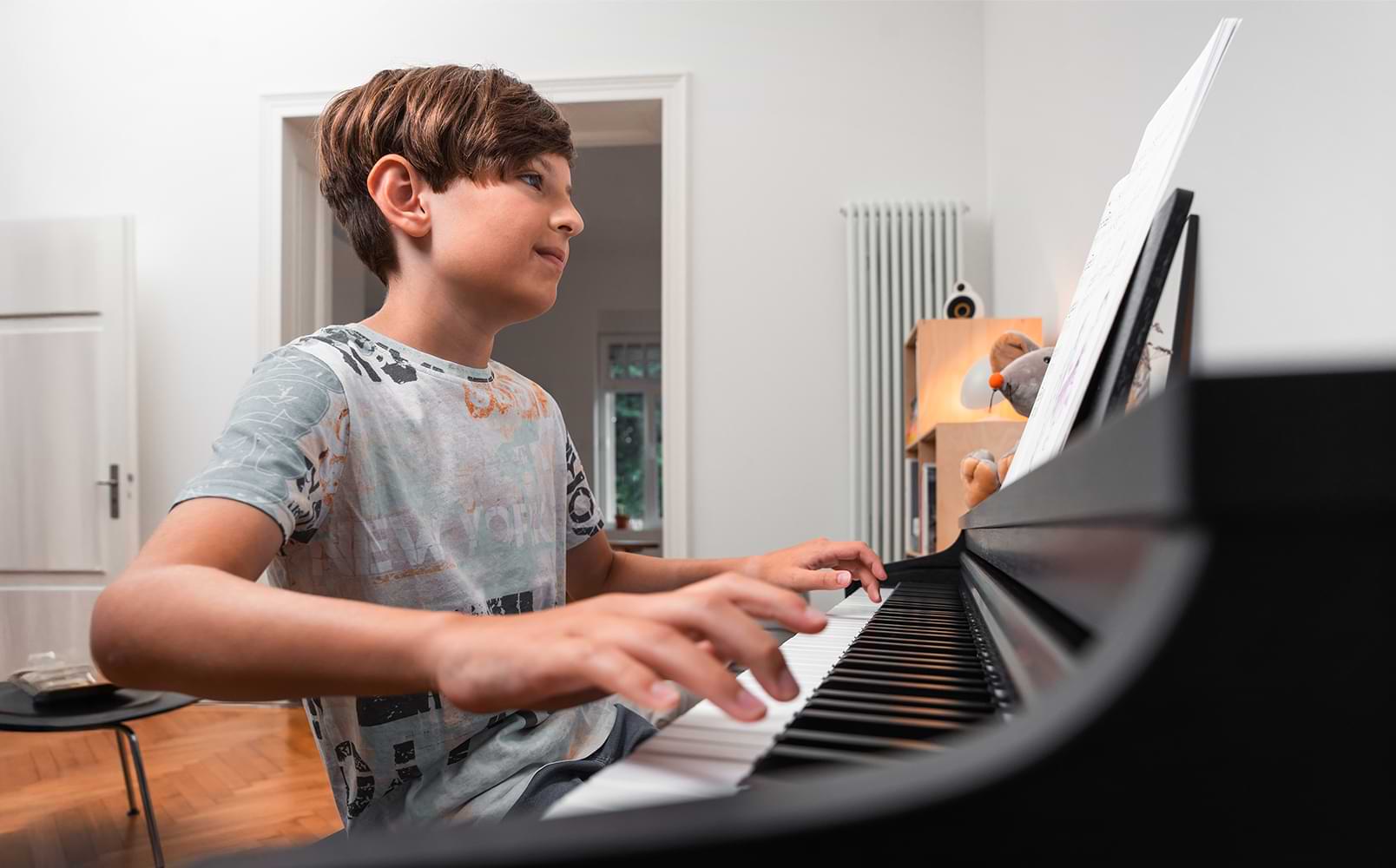 A young boy enjoys playing the CX202 digital piano